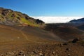 Looking down in the Haleakala Crater while clouds are being blown over the mountain ridge, Maui island, Hawaii Royalty Free Stock Photo