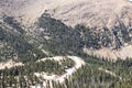 Looking down from near the summit of Pikes Peak at a hairpin curve near the treeline with tiny cars navigating it and tall pine fo Royalty Free Stock Photo