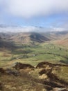 Looking down at a pastoral mountain valley; cloud inversion on peaks Royalty Free Stock Photo