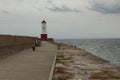 Looking down a pier at a Lighthouse on the end Royalty Free Stock Photo