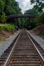 Looking down railroad tracks at a wooden bridge Royalty Free Stock Photo