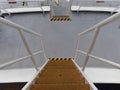 Looking down a series of stairways between decks of a Vessel with its Yellow anti skid plates