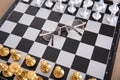 Looking down and shooting the facing chess pieces on the chessboard and a pair of glasses between the two sides Royalty Free Stock Photo