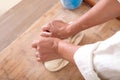 Looking down and shooting the pastry chef kneading the dough on the cutting board vigorously Royalty Free Stock Photo