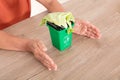 Looking down shot Chinese women`s hands pampering the green bin. The Chinese characters on the trash can mean`Kitchen waste`and `E