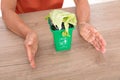 Looking down shot Chinese women`s hands pampering the green bin. The Chinese characters on the trash can mean`Kitchen waste`and `E