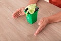 Looking down shot Chinese women`s hands pampering the green bin. The Chinese characters on the trash can mean`Kitchen waste`and `E