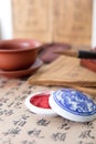 Looking down shot of the seal and inkpad on the background of Chinese calligraphy