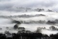 Looking down on snow covered English farmland. With trees and hedgerows silhouetted on a cold, winters, foggy day