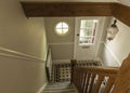 Looking down a stairway at a black and white tiled floor