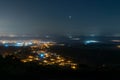 Looking down on a town and street lights at night, covered in fog. With the planet Venus glowing in the night sky