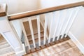 Looking down on U shaped indoor staircase with white baluster and brown handrail