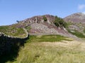 Looking down wall to heather covered mountains