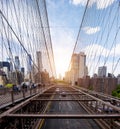 Looking east from the Brooklyn Bridge facing a bright sun rising above the skyscrapers into a blue sky Royalty Free Stock Photo