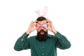 Looking for Easter goods. Hipster with long ears holding egg. Culture customs and traditions. Easter bunny colored eggs