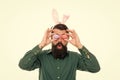 Looking for Easter goods. Hipster with long ears holding egg. Culture customs and traditions. Easter bunny colored eggs