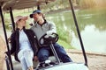 Looking forward to a round of golf. a smiling young couple riding in a cart on a golf course. Royalty Free Stock Photo