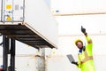 Looking forword. Foreman using laptop computer in the port of loading goods. Foreman showing thumbs up on Forklifts in the