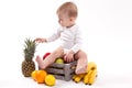 Looking at fruit cute smiling baby on white background among fru