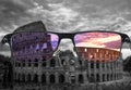 Looking through glasses to colorful Colosseum Coliseum in Rome at sunset against purple cloudy sky, Italy. Different world Royalty Free Stock Photo