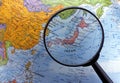 Looking at globe using magnifying glass (Asia Region)