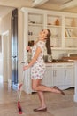 Looking good while working hard. Portrait of a young woman having fun while mopping a kitchen floor. Royalty Free Stock Photo