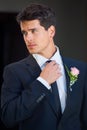 Looking great on his big day. A handsome groom wearing a pink rose on his jacket isolated on a black background. Royalty Free Stock Photo