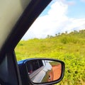 Looking at the landscape of nature and the side of the vehicle through the rear-view mirror. At normal speed enjoying nature Royalty Free Stock Photo