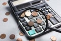 Looking through magnifying glass at calculator with coins on grey table, closeup. Search concept