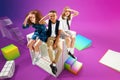 Looking for new knowledges. Children, school boy and girls sitting on 3D school supplies over colorful background Royalty Free Stock Photo