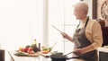 Senior woman using digital tablet at kitchen, panorama Royalty Free Stock Photo