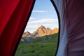 Looking out the mountain landscape at sunrise from interior of camping tent. Adventure traveling on the majestic European Alps, su Royalty Free Stock Photo