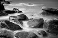 Looking out over a calm blue ocean view of shoreline with sea waves crashing on rocks Royalty Free Stock Photo