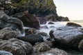 Ocean waves splash over rocks at the beach