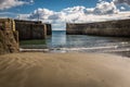 Looking at out towards the entrance of Charlestown harbour in Cornwall, England, shot from the sands Royalty Free Stock Photo