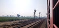 Looking out of the window of a express train of Indian railways with a view of green farm lands