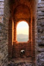 Looking out the window of guard tower during a sunset on the unrestored great wall of China