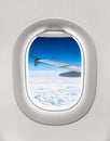 Looking out the window of a plane to the aircraft wing and cloud Royalty Free Stock Photo