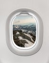 Looking out the window of a plane to the mountains Royalty Free Stock Photo