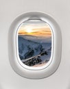 Looking out the window of a plane to the winter mountains Royalty Free Stock Photo