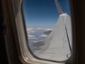 Looking Outside a Window of an Aircraft Cabin: White Airplane Wing and Clouds Royalty Free Stock Photo