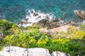 Looking over a cliff edge with blue sea below and Cliff edge and the sea. Stones worn smooth along the top of a cliff and a blue