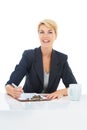 Looking over the documents with a cup of coffee. Portrait of a young businesswoman drinking coffee while filling in some Royalty Free Stock Photo