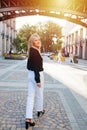 Looking over her shoulder attractive young blond woman walking down the road Royalty Free Stock Photo