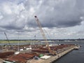 Looking over a Quay filled with Pipework of Varying sizes and other equipment going to be used in a Maritime Setting.