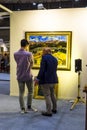 Looking at a painting at Lorenart at Antik Passion Almoneda 2023 fair at IFEMA Madrid, Spain