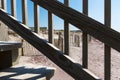 Looking through the railing of a staircase on the beach at fencing protecting the dunes Royalty Free Stock Photo