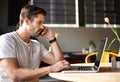 Looking at it right now. a handsome young man using a laptop and talking on his cellphone in a cafe. Royalty Free Stock Photo