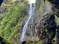 Rabacal - Looking through rocky cave on majestic waterfall Cascata Risco along idyllic Levada walk 25 fountains Royalty Free Stock Photo