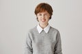 Looking sassy today. Studio portrait of attractive emotive redhead woman with cute freckles squinting and showing teeth